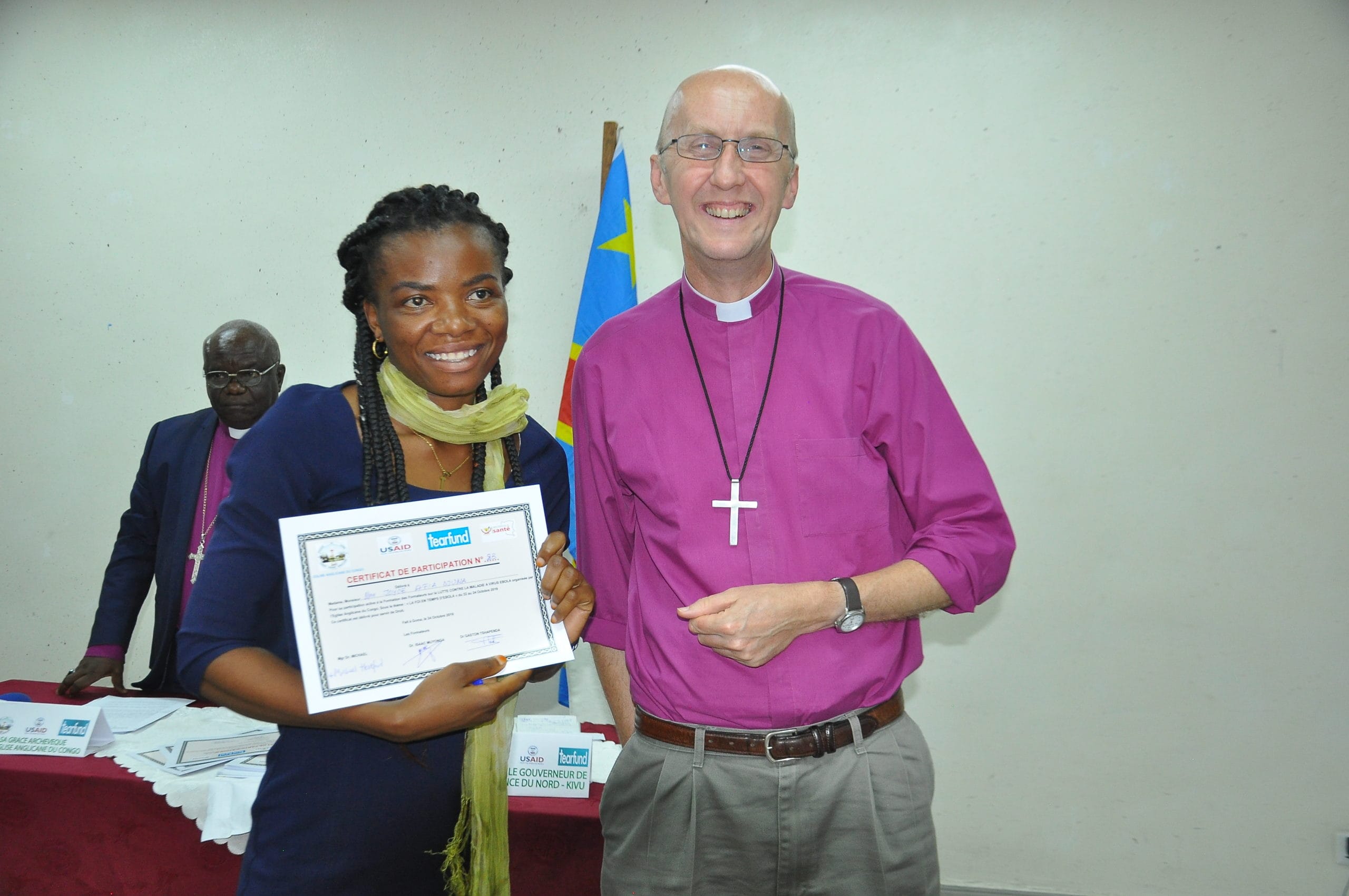 Faith leader (left) receives certificate of completion of Ebola training.