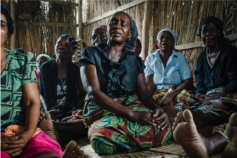 Women involved in a Care Group program to involve communities in educating their neighbors about health issues gather in Mozambique to learn about TB.