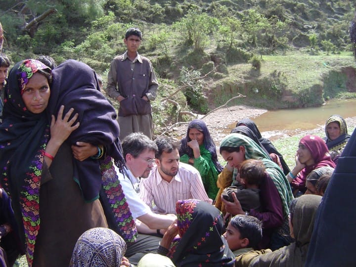 A group of nomadic men, women and children near a riverbed in India. 