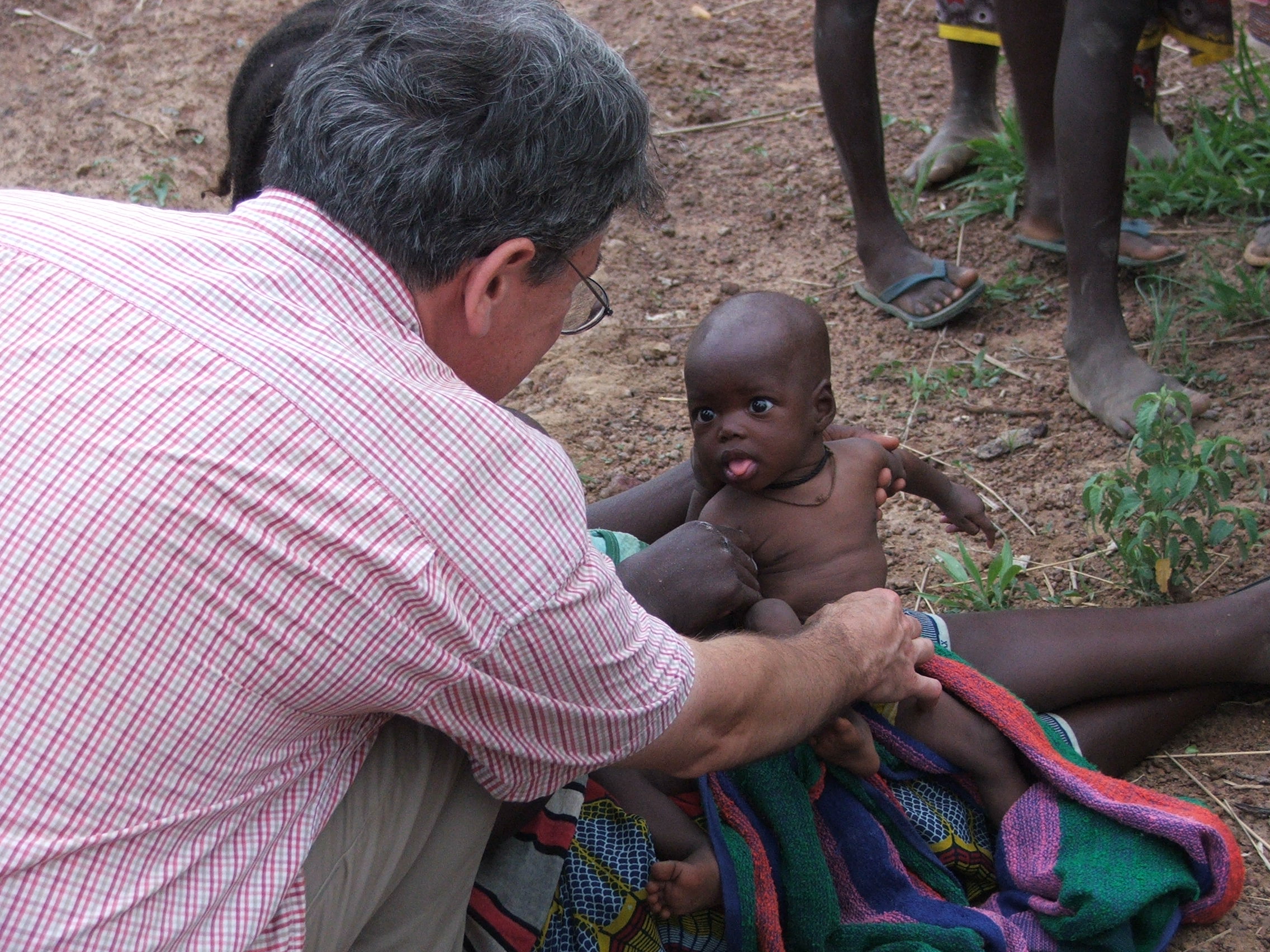 Doctor examines infant in Burkina Faso.