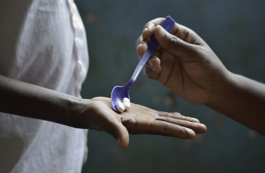 A student receives medicines to fight neglected tropical diseases in Tanzania as part of a mass drug administration.