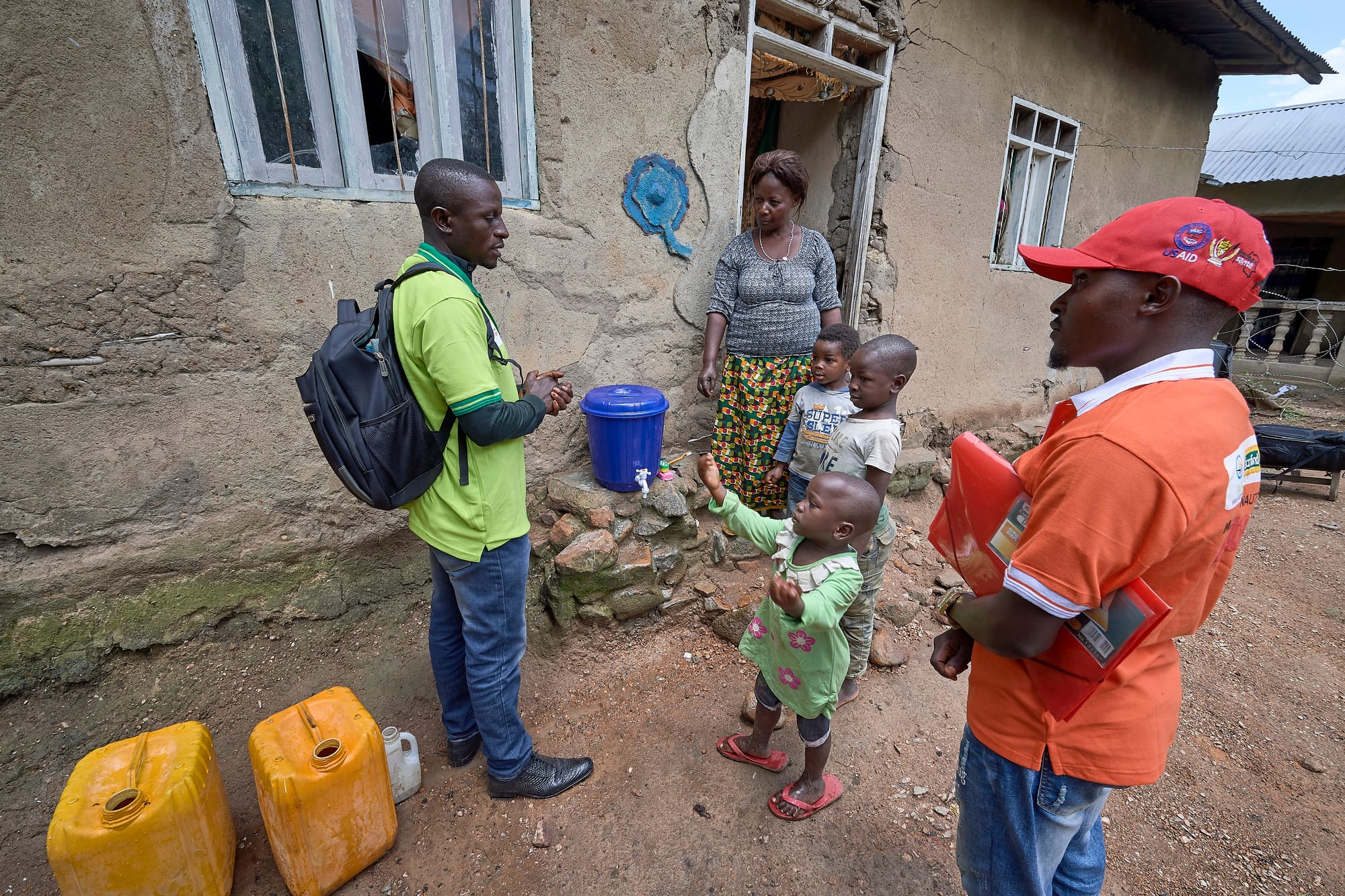 A community health promoter talks with children in front of their home in Beni, a city in eastern Democratic Republic of the Congo that was hard hit by the Ebola outbreak that began in 2018.