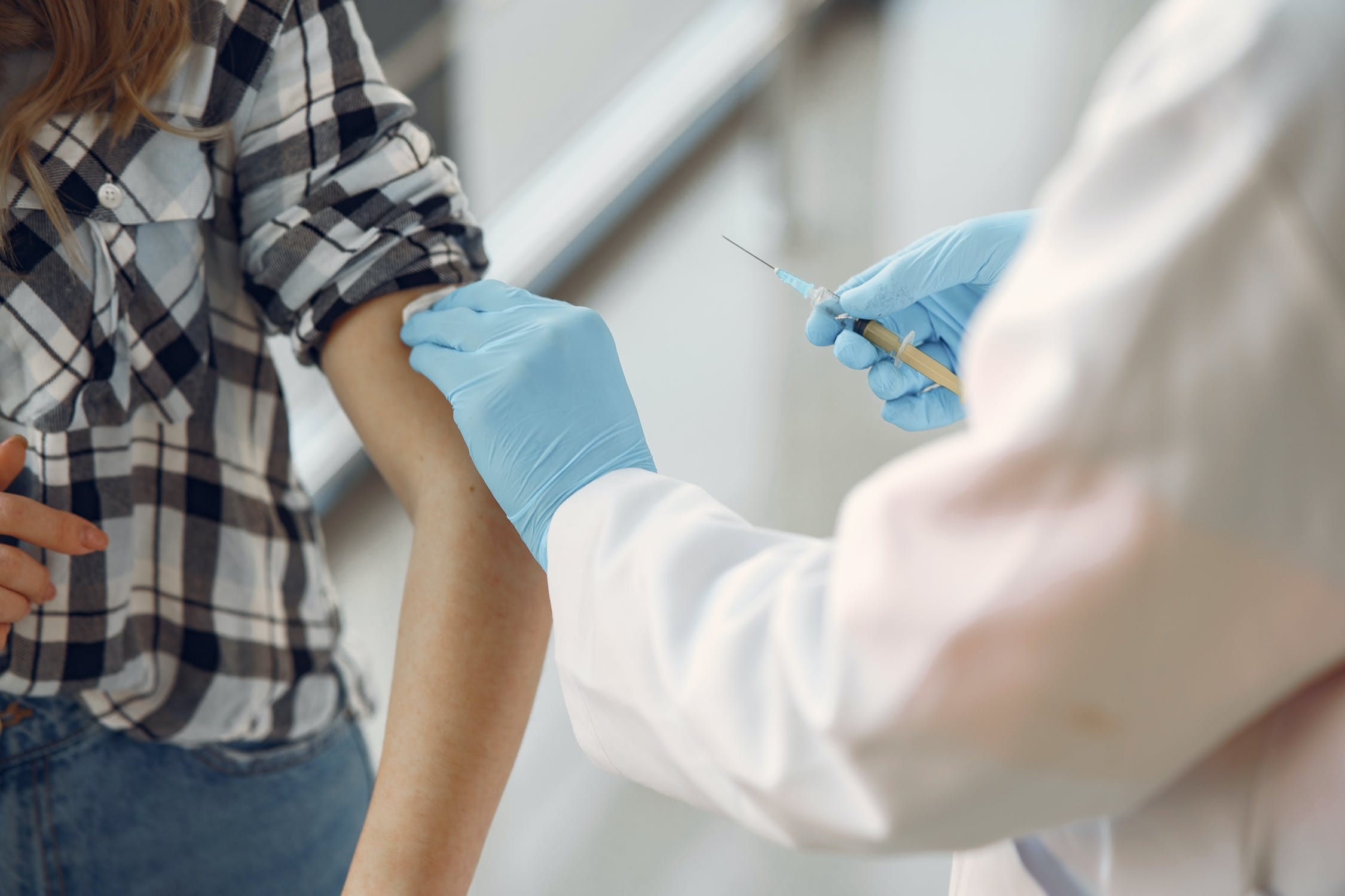 Heath worker about to inject a patient's arm with a vaccine.