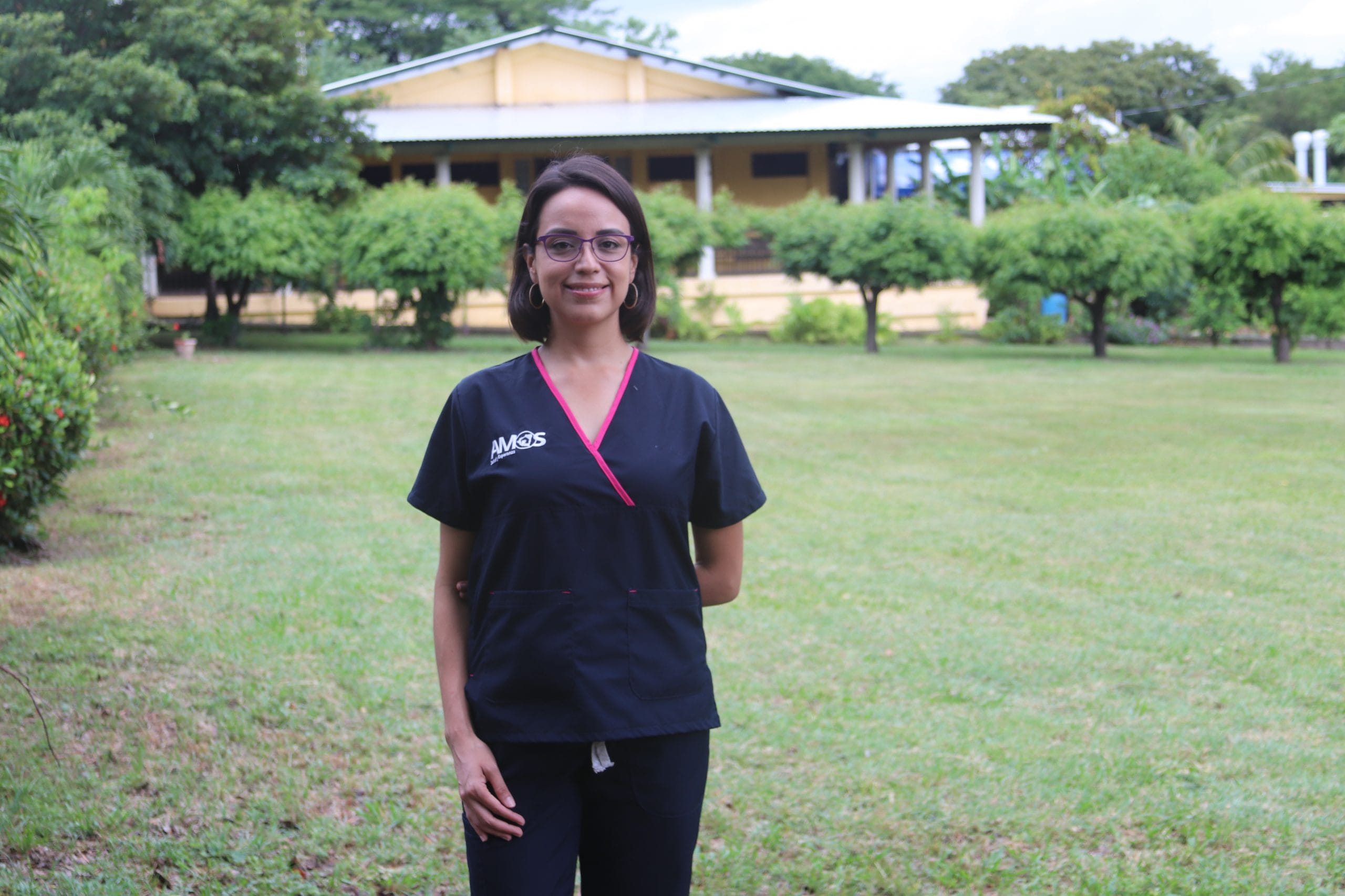 A woman is shown outside in doctors' scrubs