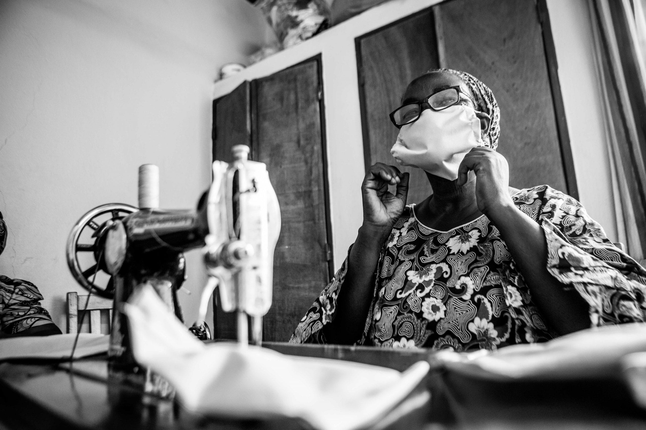 A woman wearing a face mask sits at a sewing machine at the CURE Niger Hospital