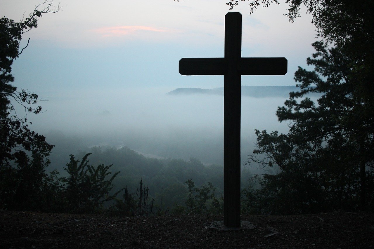 A cross outside in front of an area covered with fog