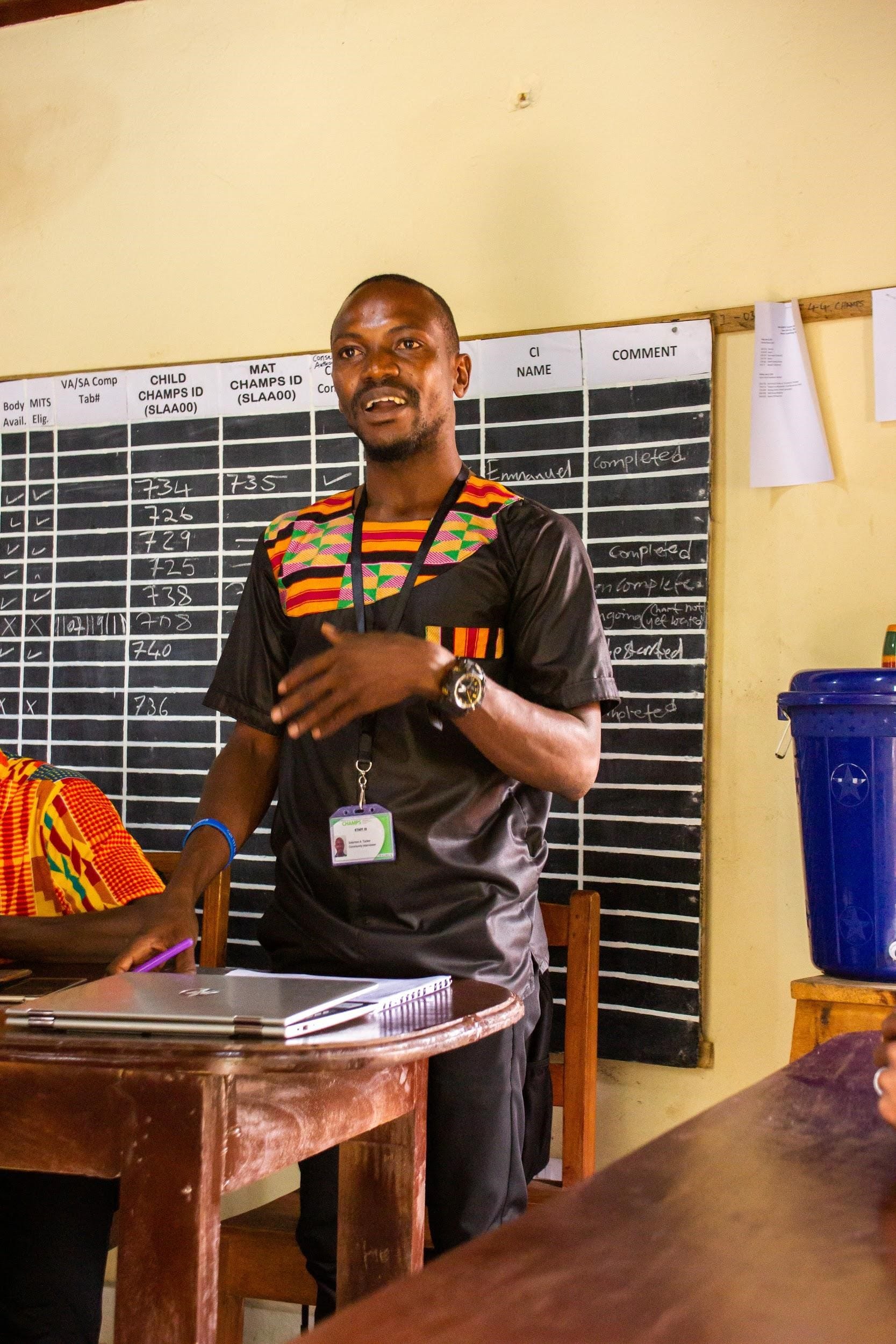 A nurse stands in front a board discussing data gathered from a health case.