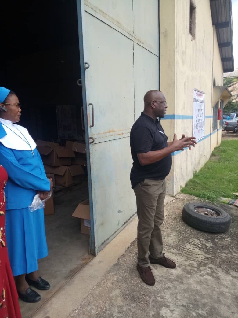 Mr. Mike Idah General Secretary of CHAN stands outside the office talking to people about personal protective equipment