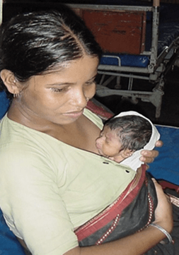 A mother holds a child on her chest in what is referred to as Kangaroo care.