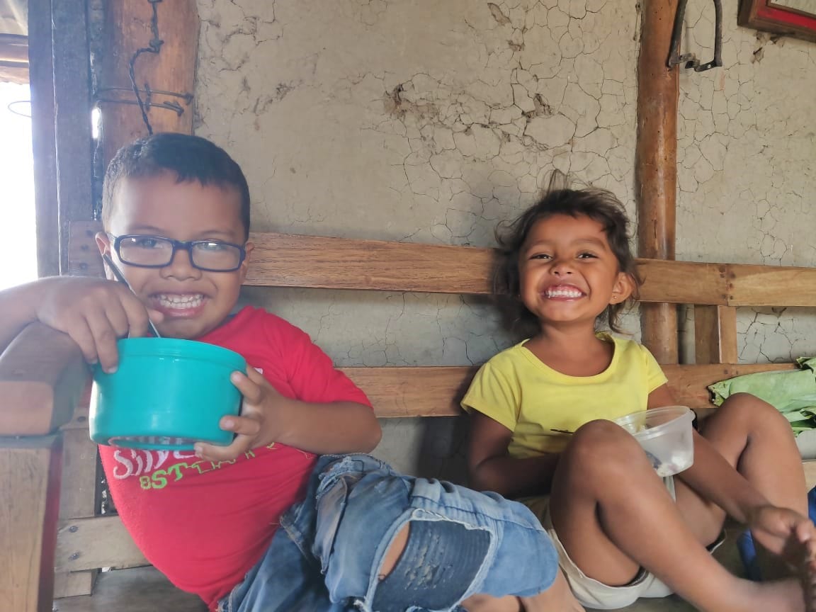 A young boy and girl eat in Nicaragua