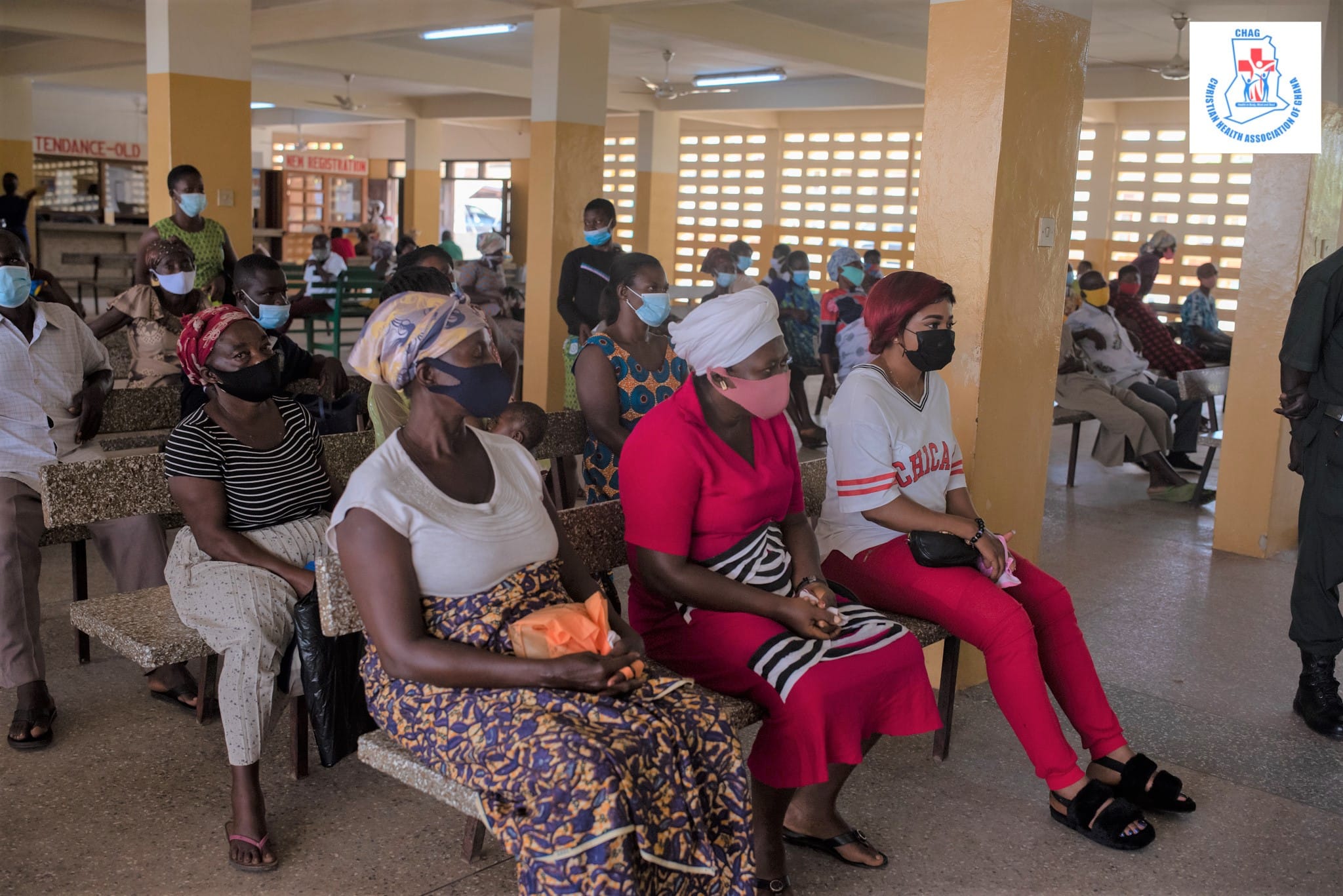 Women sit in rows listening to COVID educational messages