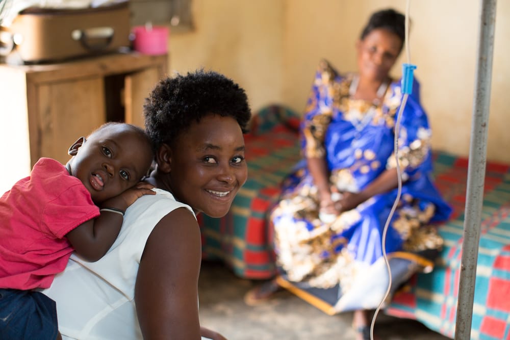 A young boy perches on his mother's back while at a health facility in Uganda. 