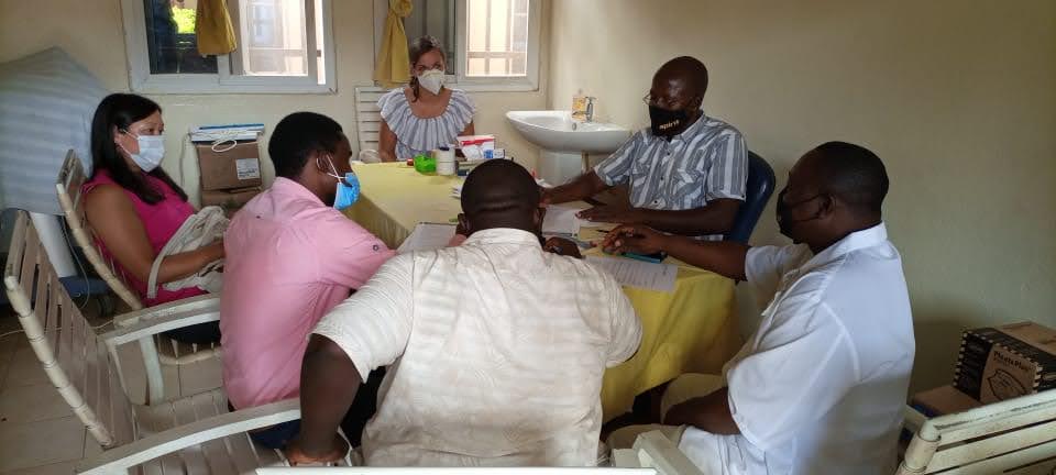 A group of men and women sit around a table reviewing documents.