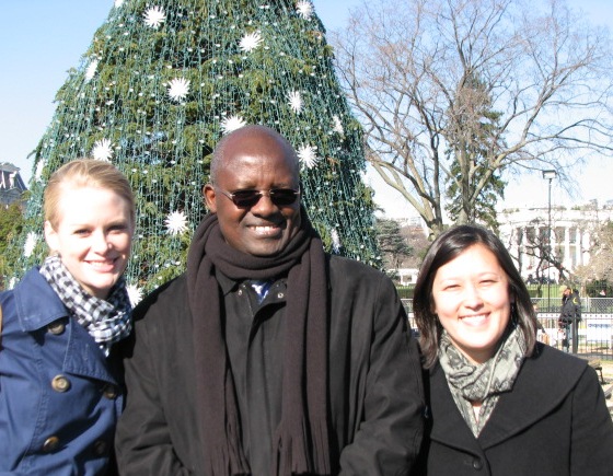 A man and two women in front of a Christmas tree.